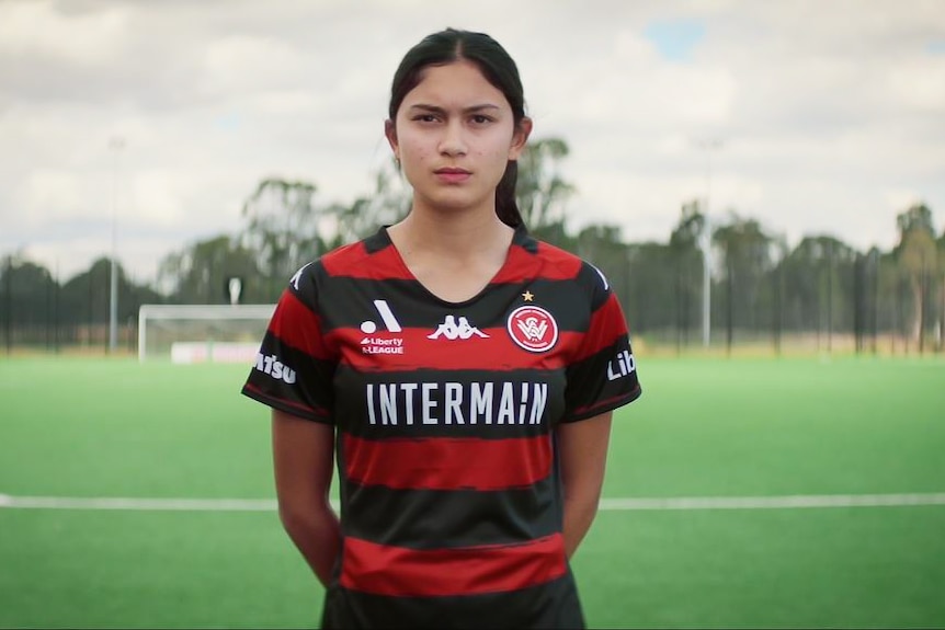 A still from a video showing a young women soccer player looking stern
