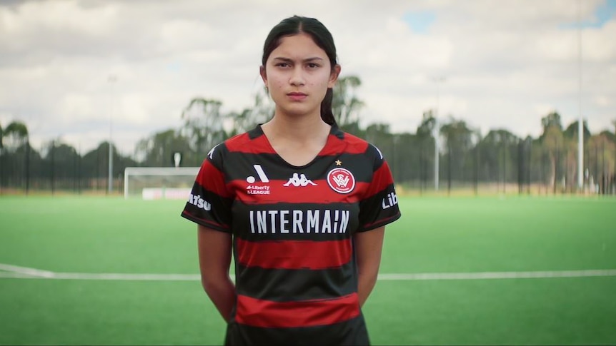 A still from a video showing a young women soccer player looking stern