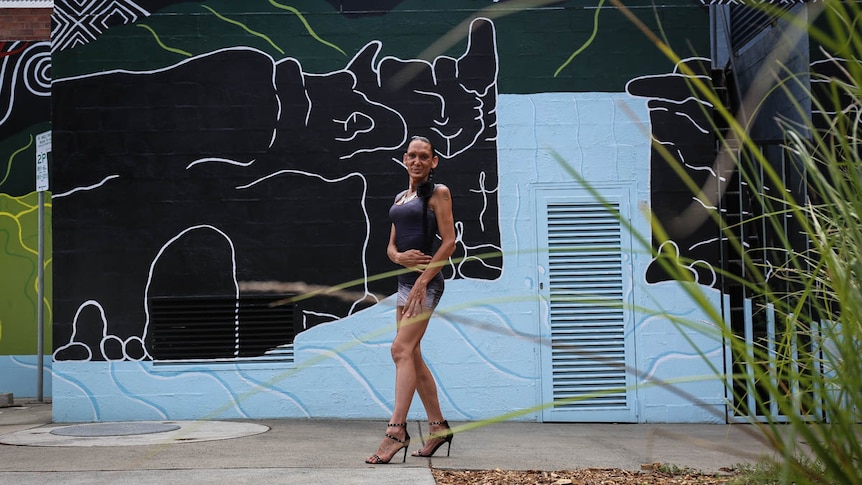 Elytta Manton poses in front of mural
