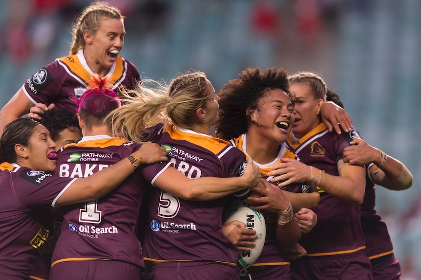 Teuila Fotu-Moala is mobbed by her Broncos teammates after scoring a try against the Roosters.