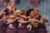 Teuila Fotu-Moala is mobbed by her Broncos teammates after scoring a try against the Roosters.
