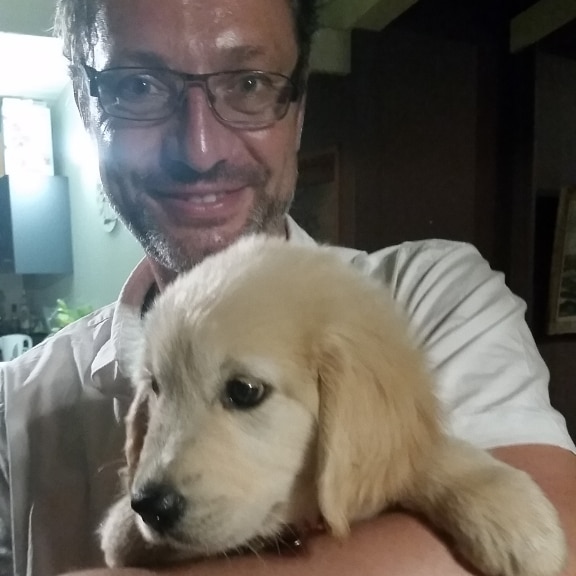 Man holding a puppy, smiling