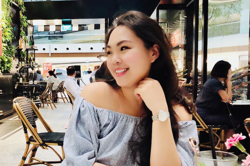 Lin Li-Jie at a restaurant, smiling and looking to the side past her shoulder.