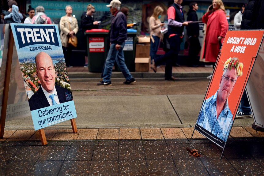 A Trent Zimmerman corflute at a North Sydney polling booth a day before the 2022 election across from a Scott Morrison sign