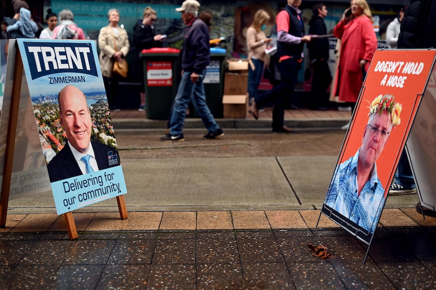 A Trent Zimmerman corflute at a North Sydney polling booth a day before the 2022 election across from a Scott Morrison sign