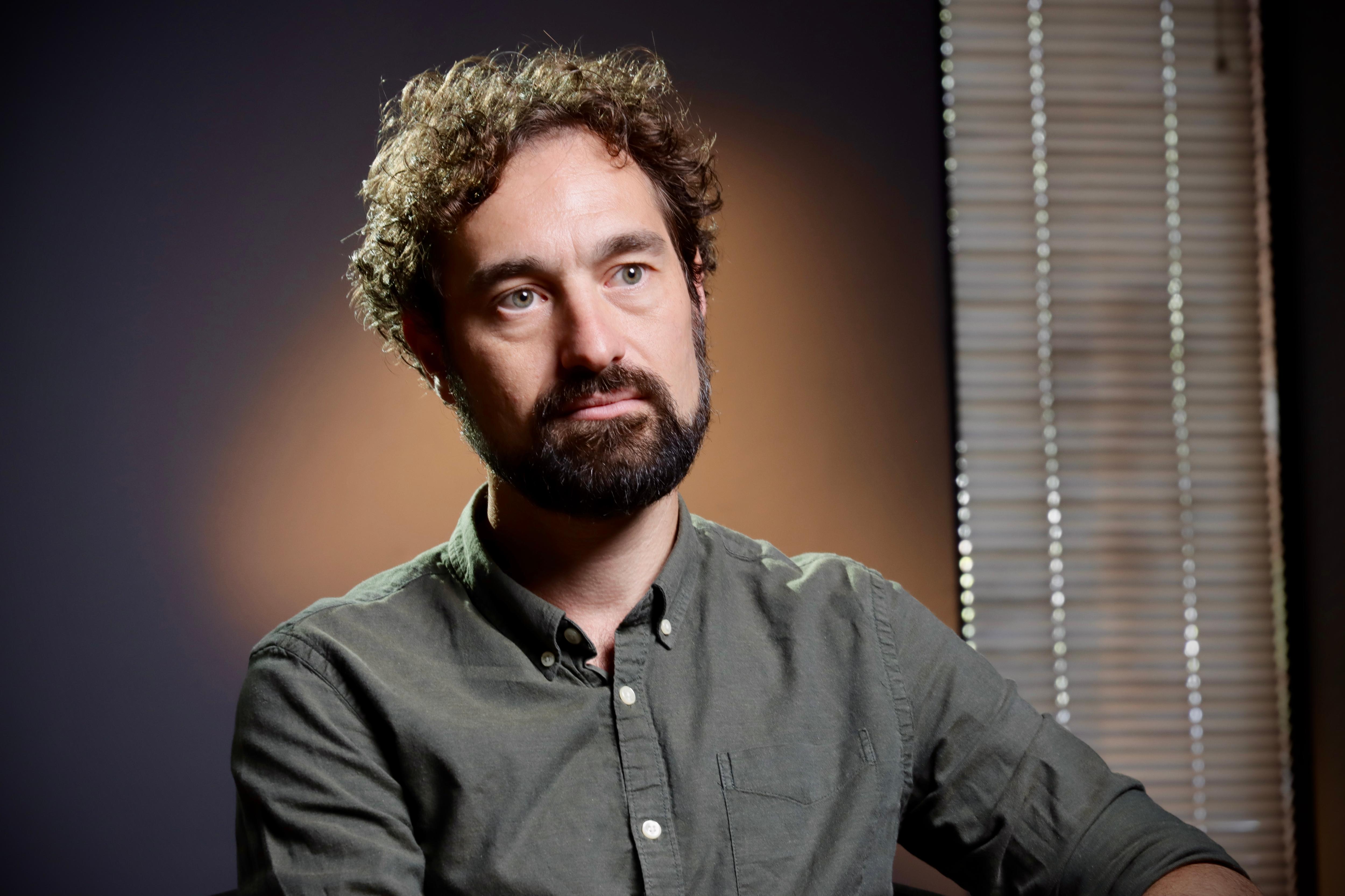 a man with dark facial hair looking serious