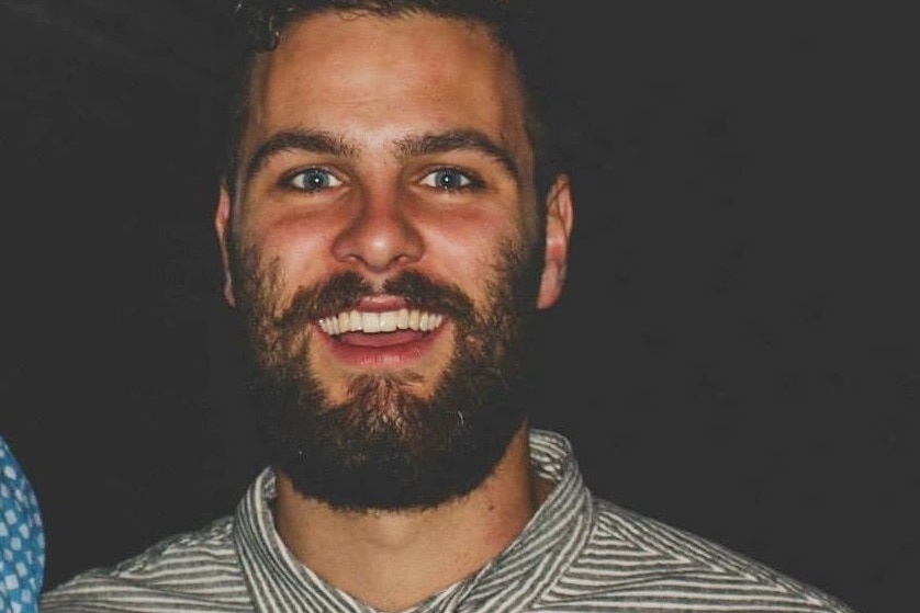 Bearded smiling man looks at camera