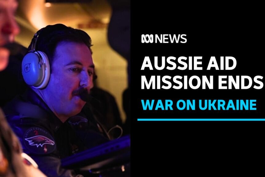 Aussie Aid Mission Ends, War on Ukraine: A man wearing a radio headset is shrouded in purple light.