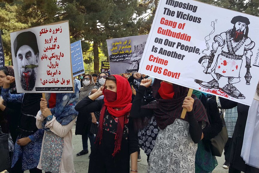 Protesters carry signs against the Hizb-i-Islami