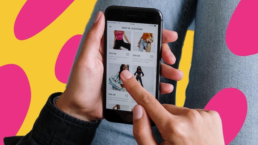 A person holds a phone and scrolls through a clothes shopping site