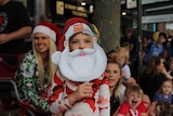 A child wearing a Santa mask at the pageant