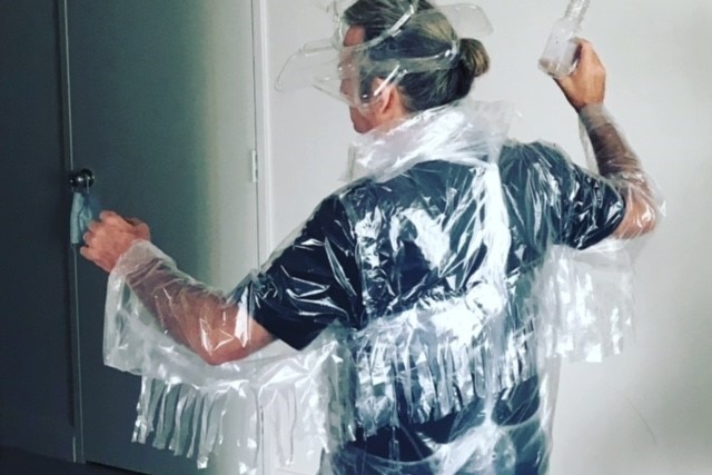 Un homme vêtu d'un costume en film plastique prend la pose.