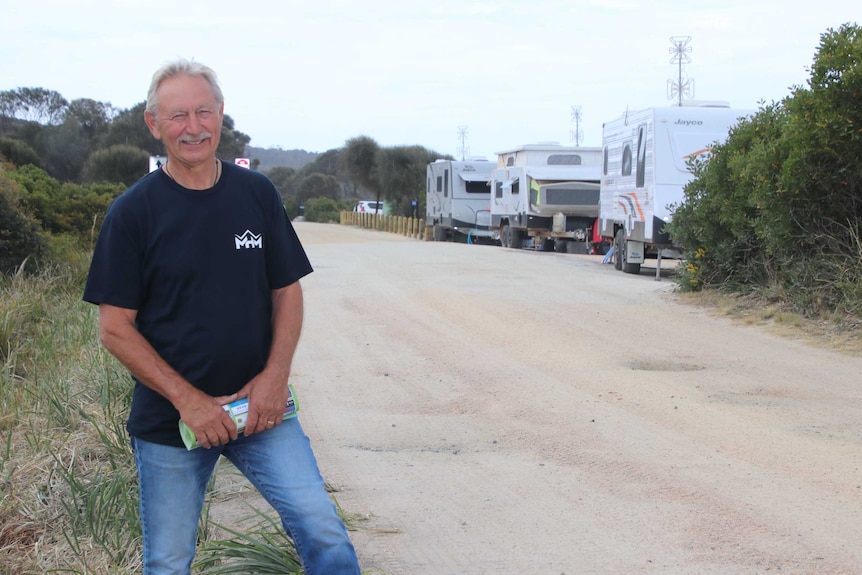 St Helens Chamber of Commerce president Peter Paulson standing near campervans at Swimcart Beach