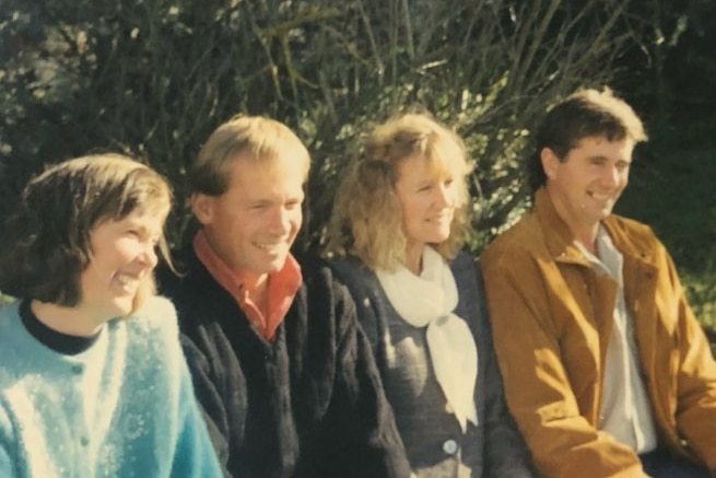 Carol and her family smiling in a row. 