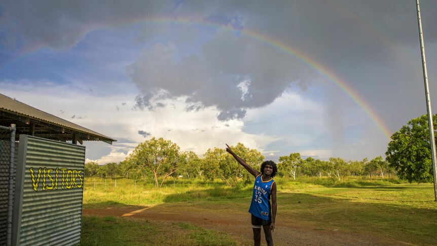 The Warriors star Gordon Churchill in his hometown Warmun with a rainbow overhead