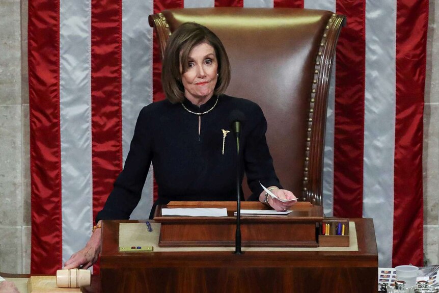 Nancy Pelosi stands at her raised desk as House Speaker.