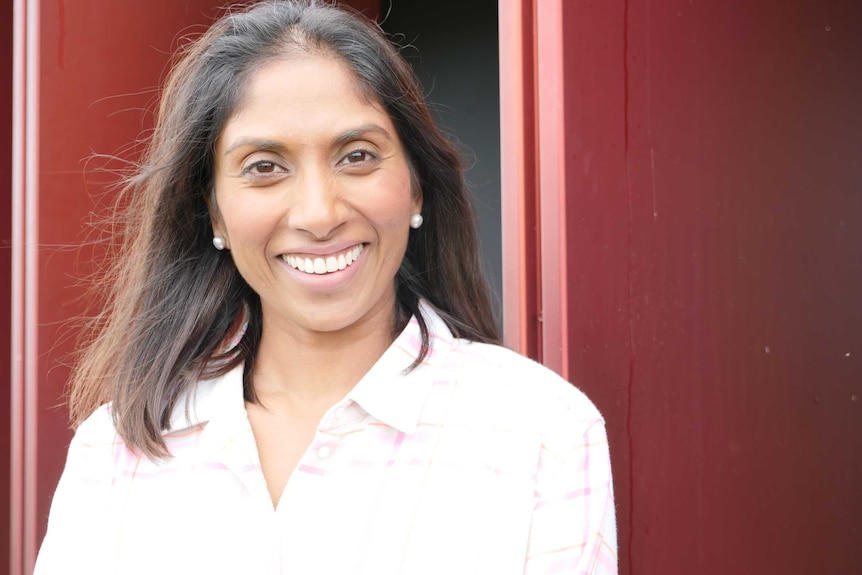 Nutritionist Anneline Padayachee stands in front of red dairy