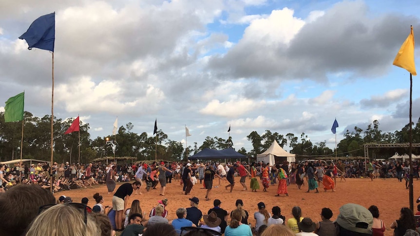 Traditional dancers in modern dress in Arnhem Land are surrounded by a circle of onlookers at the Garma Festival