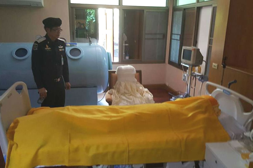 Thai police examine Phra Dhammachayo's bed before the blankets are pulled back to reveal there is no-one there.