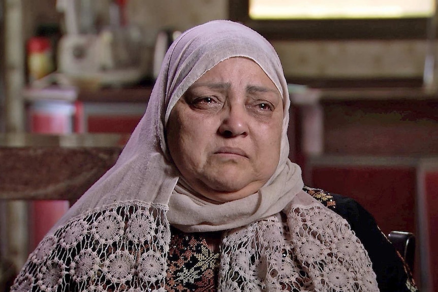 Amal Al Halabi wears a pink headscarf and has tears in her eyes.