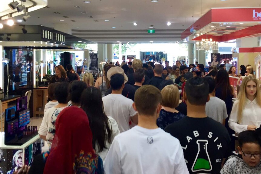 Dozens of shoppers fill the aisle in the makeup section of a Perth department store.