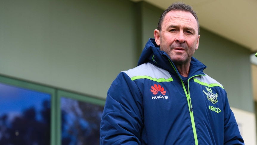An NRL coach stares at the camera while wearing a parka.