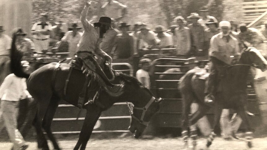 Action photo of Roland as a young man on a bucking horse.