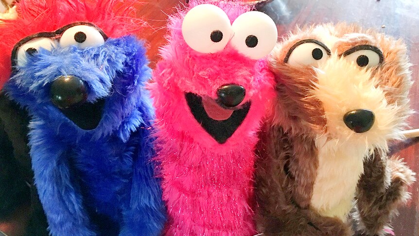 Three fury simple puppets in bright blue, pink and brown.