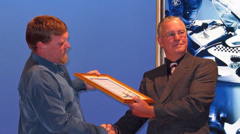 Jade Clarke receives his award from Sgt Les Cooper who was shot in 2006.