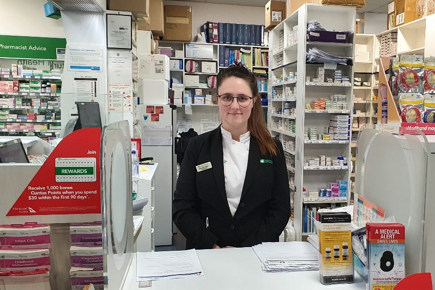 Pharmacist Gabby Wilson stands behind a counter at her pharmacy in Albury