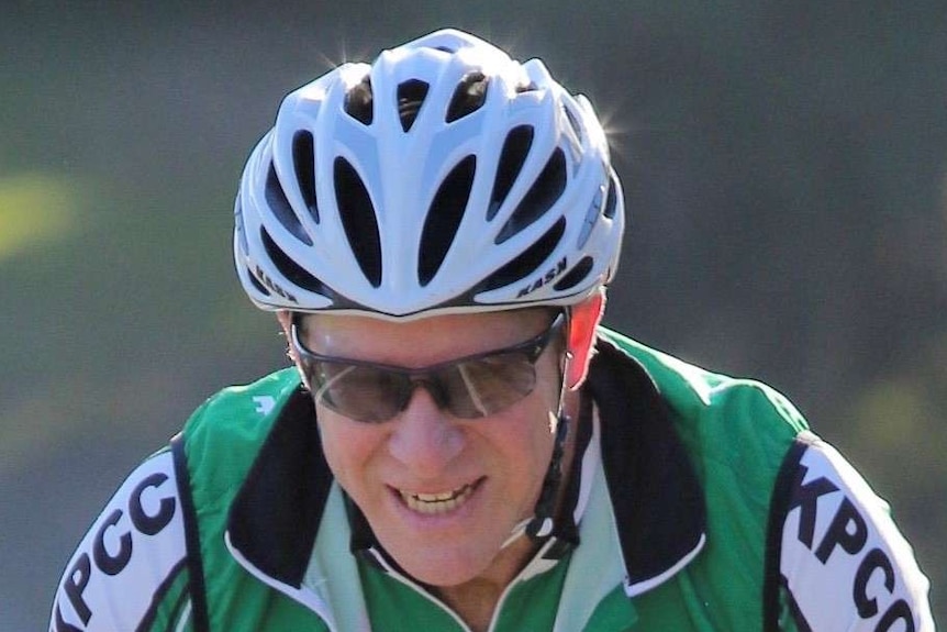 Close up of man on bike smiling.