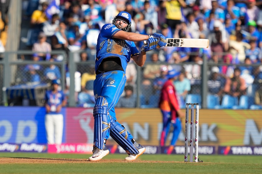 Tim David plays a hook shot during an IPL match during the day-time in India, wearing all blue