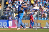 Tim David plays a hook shot during an IPL match during the day-time in India, wearing all blue