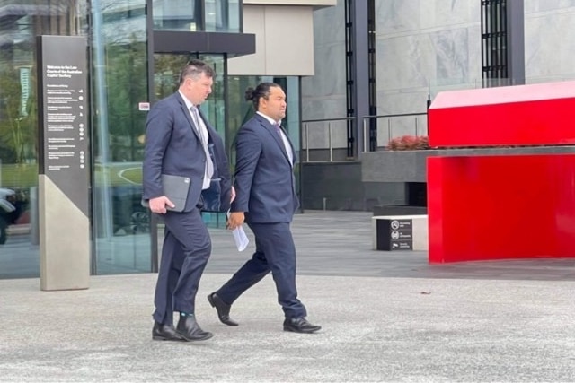Two men in a suit walk outside the ACT national courts