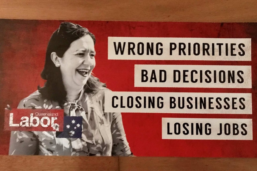 A red poster of the Queensland Premier next to the words "wrong priorities, bad decision, closing businesses, losing jobs".