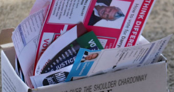 How-to-vote cards for the Victorian election in a recycling bin.