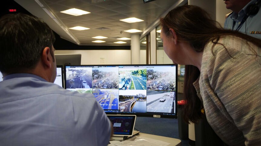 Marg Prendergast, Coordinator-general for Transport for NSW, and her team look at a screen displaying live traffic cameras.