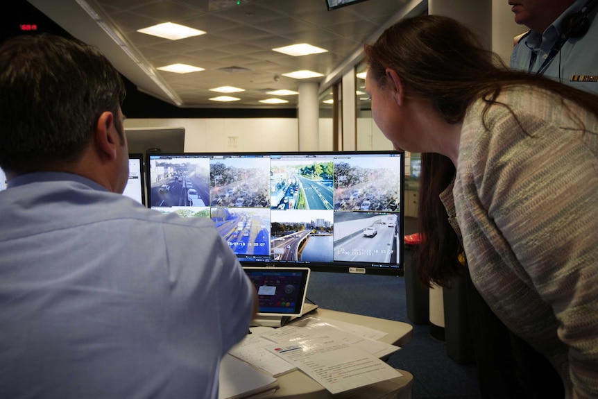 Marg Prendergast, Coordinator-general for Transport for NSW, and her team look at a screen displaying live traffic cameras.