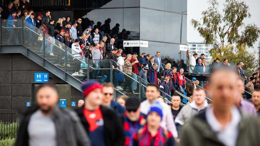 A crowd walking down the stairs at Perth Stadium station. 