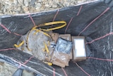 An open black bag containing wrapped up packages of an illicit drug.