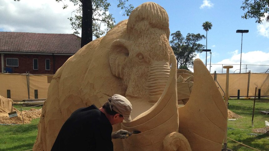 Sculptor Jaap Tichler works on his sand sculpture