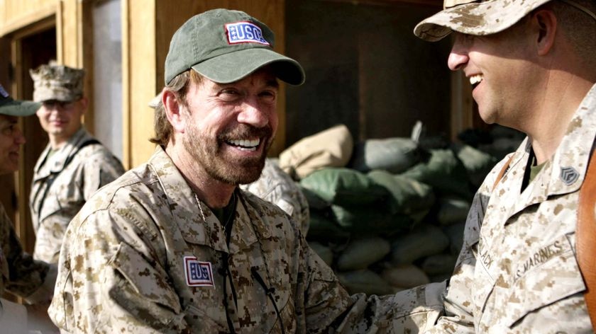 Chuck Norris shakes hands with Gunnery Sgt John C Pollack at Camp Taqaddum in Iraq