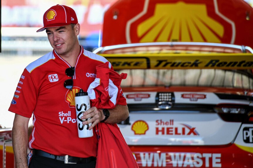Scott McLaughlin stands in front of his car.