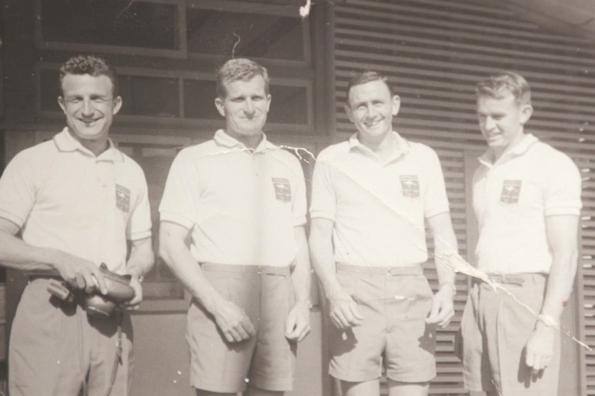 A black and white image of four men at the 1964 Olympic village in Tokyo.