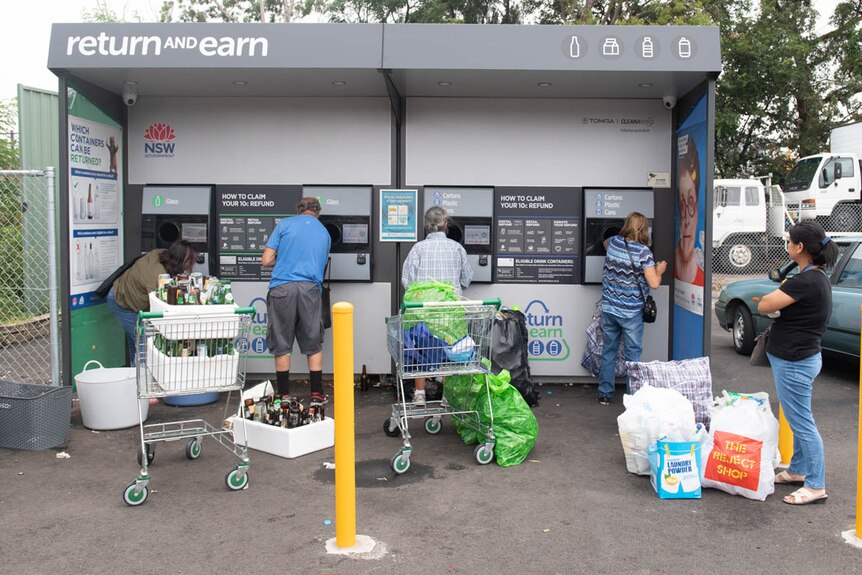 People returning bottles and cans at a NSW Return and Earn recycling booth