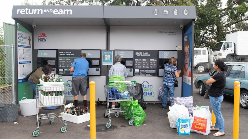 People returning bottles and cans at a NSW Return and Earn recycling booth