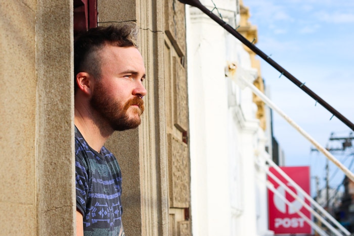 Brad Guy looking outside a window in Melbourne.