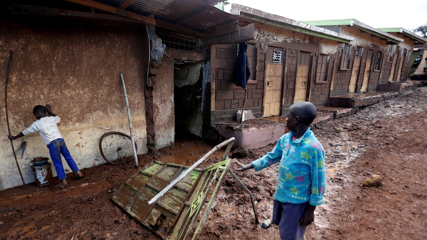 Children look at houses destroyed by flooding waters in their neighbourhood in Kenya.