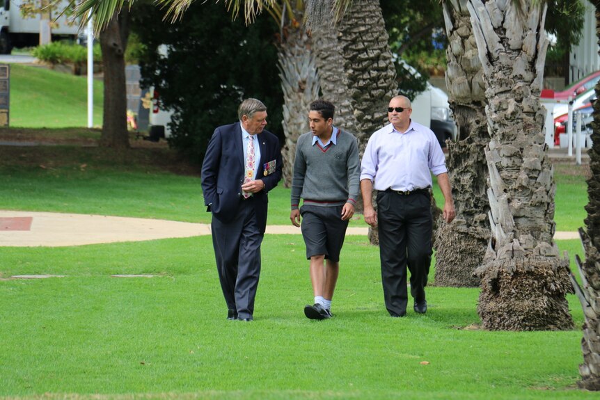 Bill Denny, Anzac Lochowiak, John Lochowiak walk through a park.