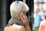 A woman talks on a mobile phone in public